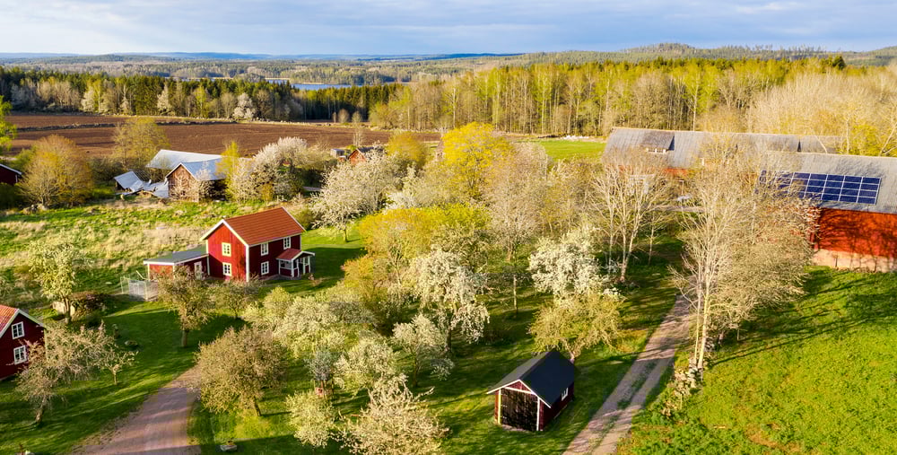 Rött trähus och ladugård på landsbygden.