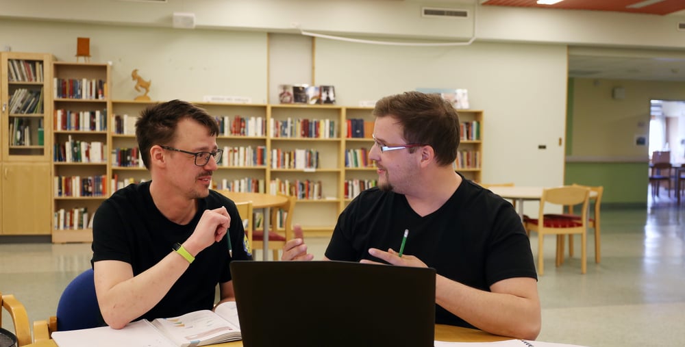 Två kursdeltagare sitter och studerar