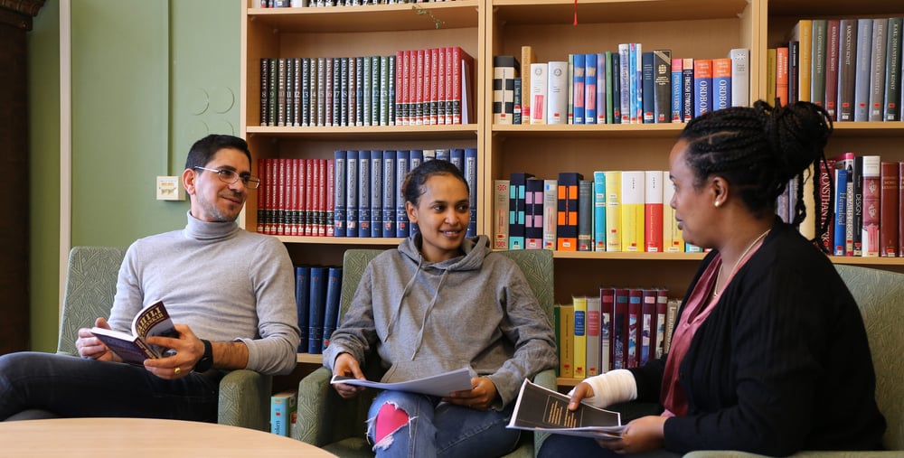 Kursdeltagare sitter i fåtöljer och läser böcker