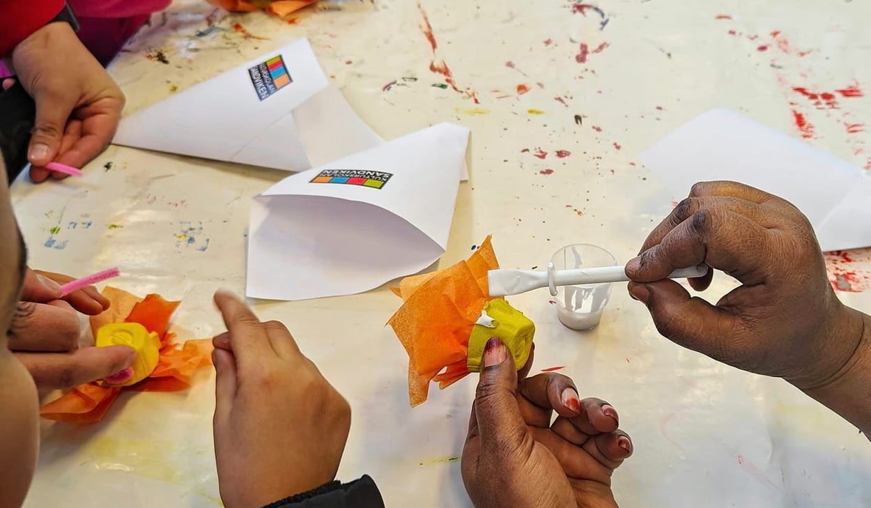 Barnhänder vid ett bord som pysslar med höstlöv