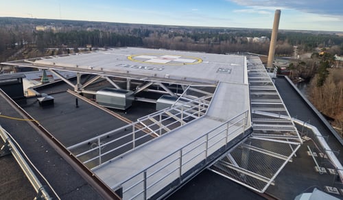 En flygbild över en helikopterflygplats med en byggnad i bakgrunden.