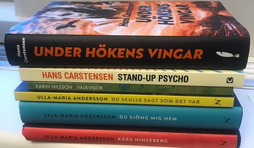 En trave böcker som ligger på ett bord.