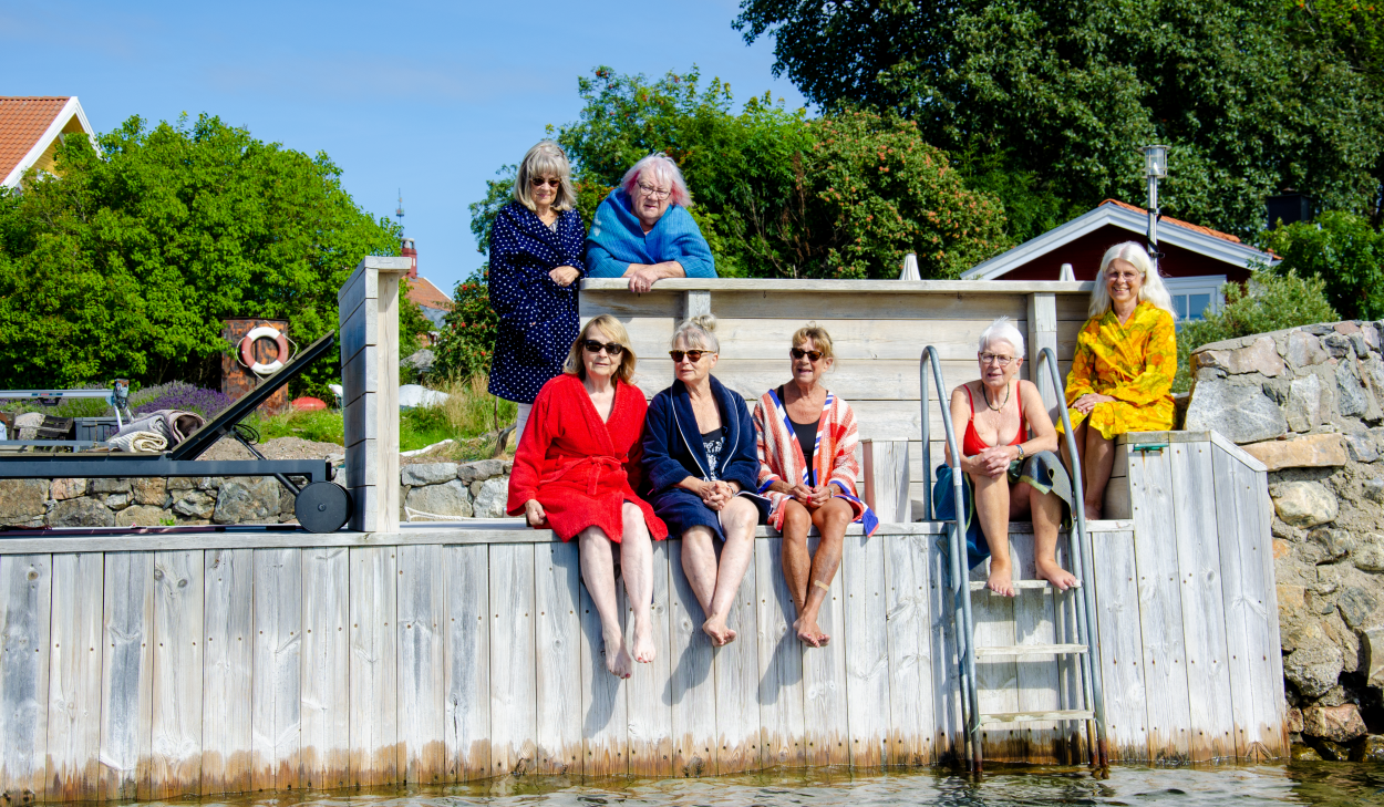 7 personer sitter på en brygga i solen